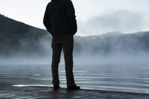 Man standing on the edge of a lake